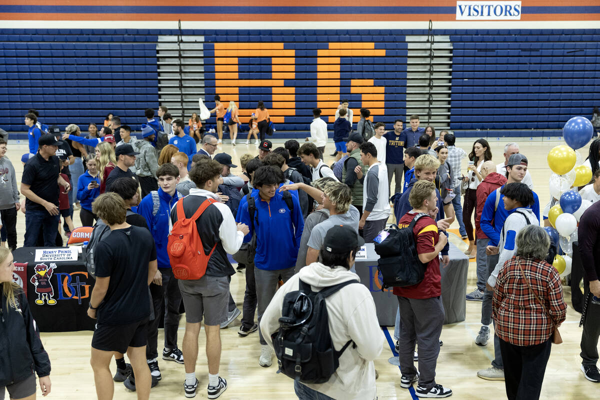 Friends and loved ones congratulate their athletes who signed their national letter of intent t ...