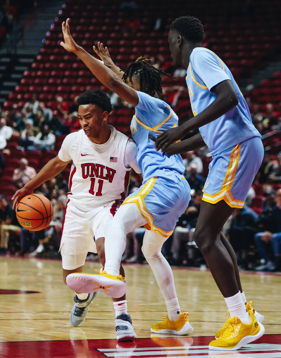 UNLV guard Dedan Thomas Jr. (11) fights to drive the ball to the hoop during a game against Sou ...