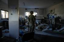 An Israeli soldier stands in what the army says was a Hamas weapons-making facility during a gr ...