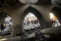 Palestinians inspect the damage of a destroyed mosque following an Israeli airstrike in Khan Yo ...
