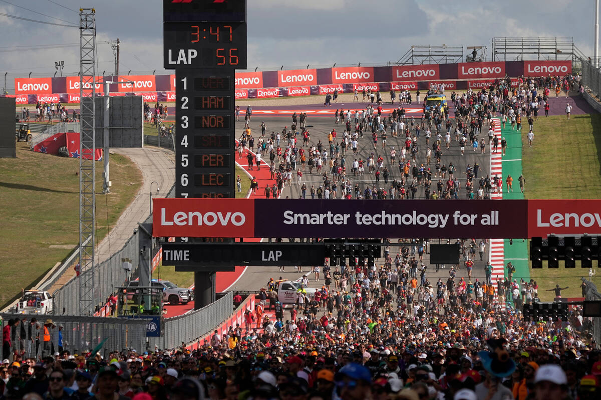 Fans walk on the track after the the Formula One U.S. Grand Prix auto race at Circuit of the Am ...