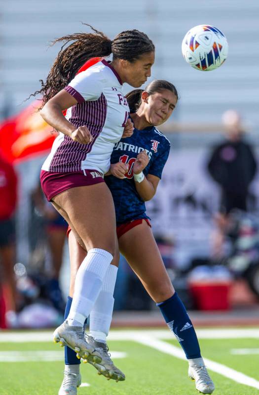 Faith Lutheran defender Jailynn Henry (42) heads the ball over Liberty midfielder Adriana Gonza ...