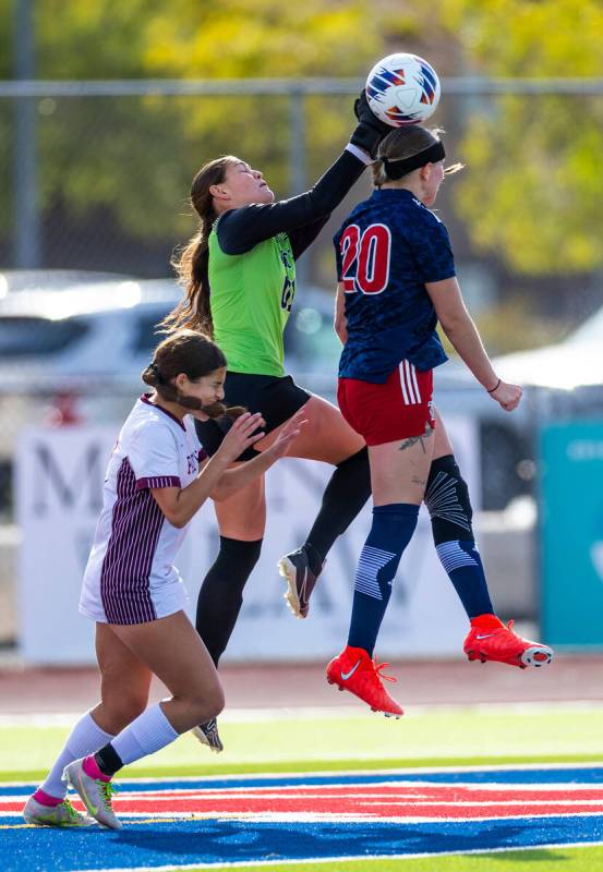 Faith Lutheran goalkeeper Demi Gronauer (01) deflects a shot away as Liberty midfielder Madisyn ...