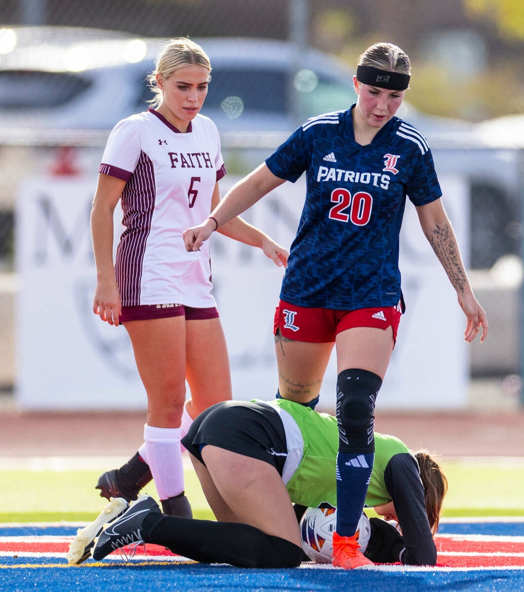 Faith Lutheran goalkeeper Demi Gronauer (01) is down on the turf after a save and bad hit from ...