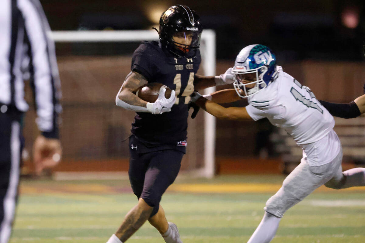 Faith Lutheran's running back Cale Breslin (14) avoids a tackle from Green Valley's defensive b ...