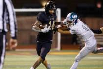 Faith Lutheran's running back Cale Breslin (14) avoids a tackle from Green Valley's defensive b ...