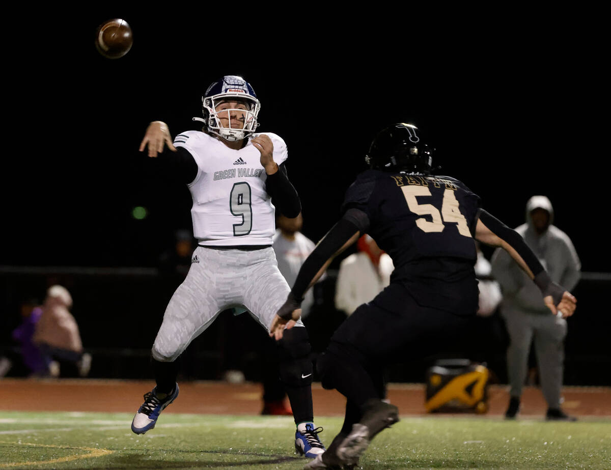 Green Valley's quarterback Jack Thow (9) throws under pressure from Faith Lutheran's Troy Jones ...