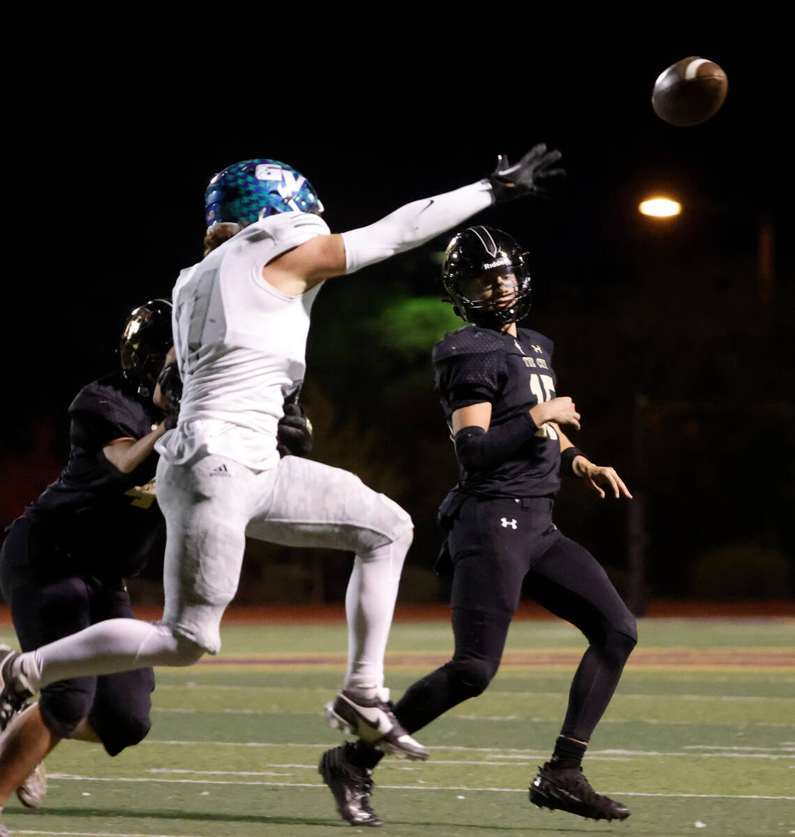 Green Valley's Gavin Blondeaux (11) tries to block a pass from Faith Lutheran's quarterback Ale ...