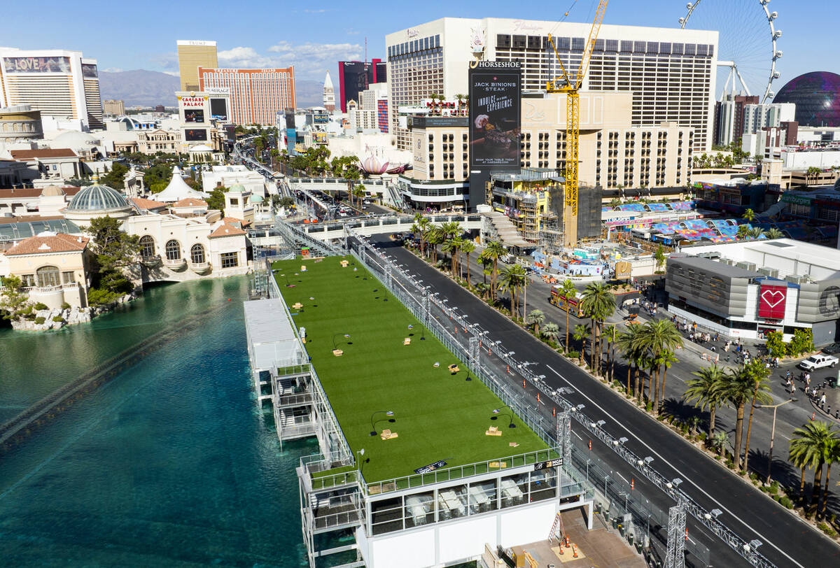 Workers add the finishing touches on the Formula One grandstands at the lake in front of Bellag ...