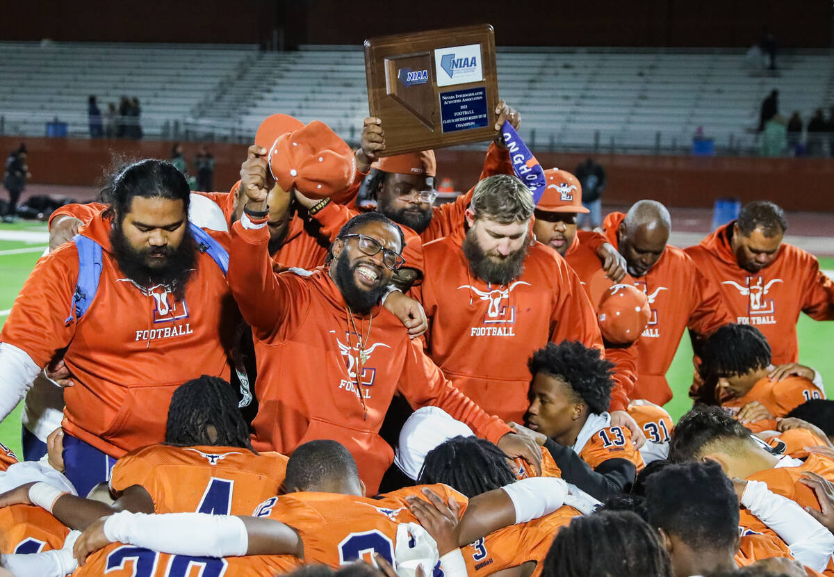 Legacy High School coaches hold up the Class 5A Division III Southern League championship troph ...