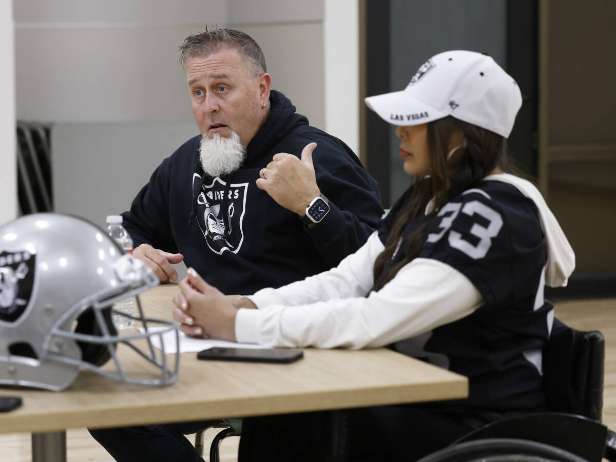 Raiders wheelchair football team head coach Bob Murray speaks as Beya Tep looks on during an in ...