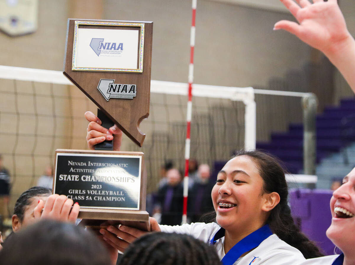 Bishop Gorman’s Leilia Toailoa (18) holds up the state championship trophy after Bishop ...