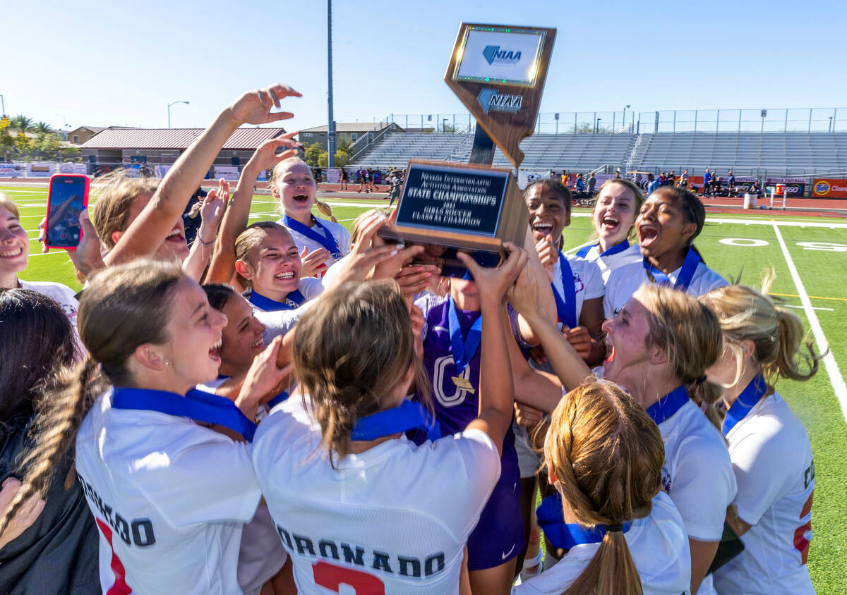 Coronado players and coaches hoist the trophy as they celebrate their 2-1 win against Faith Lut ...