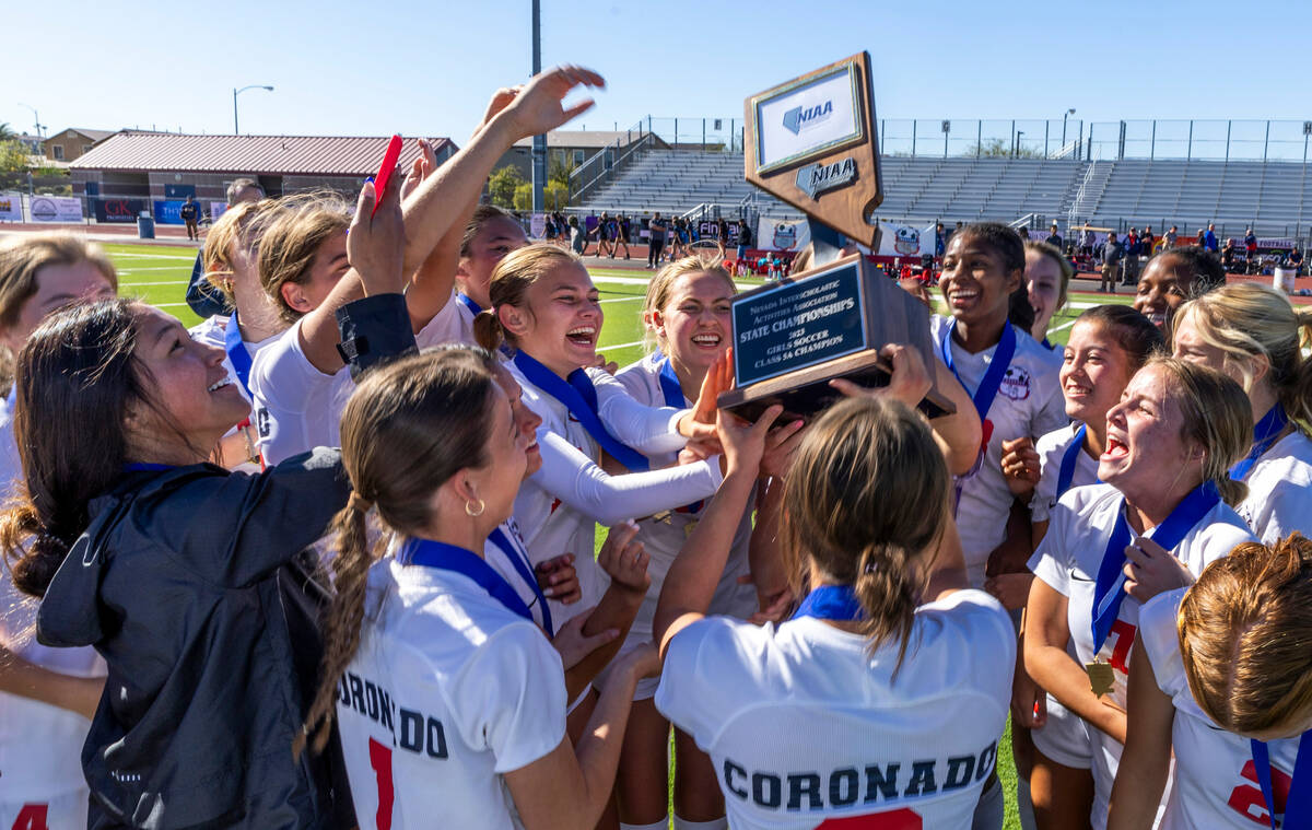 Coronado players and coaches hoist the trophy as they celebrate their 2-1 win against Faith Lut ...
