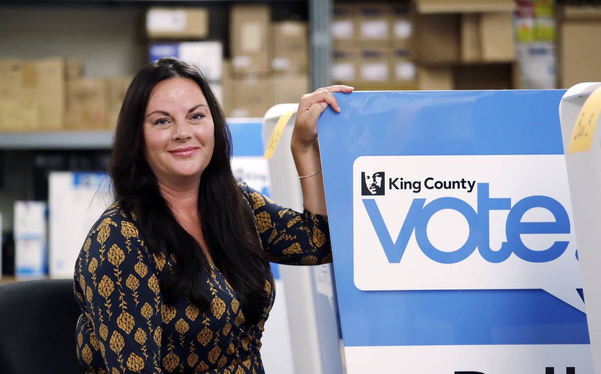 FILE - Julie Wise, King County's elections director, poses for a photo alongside a ballot drop ...