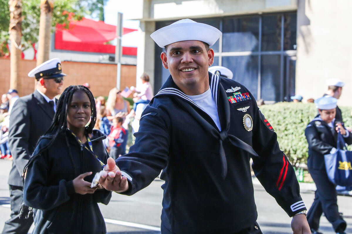 A Veteran throws items to the crowd during the annual Veterans Day parade on 4th Street in down ...