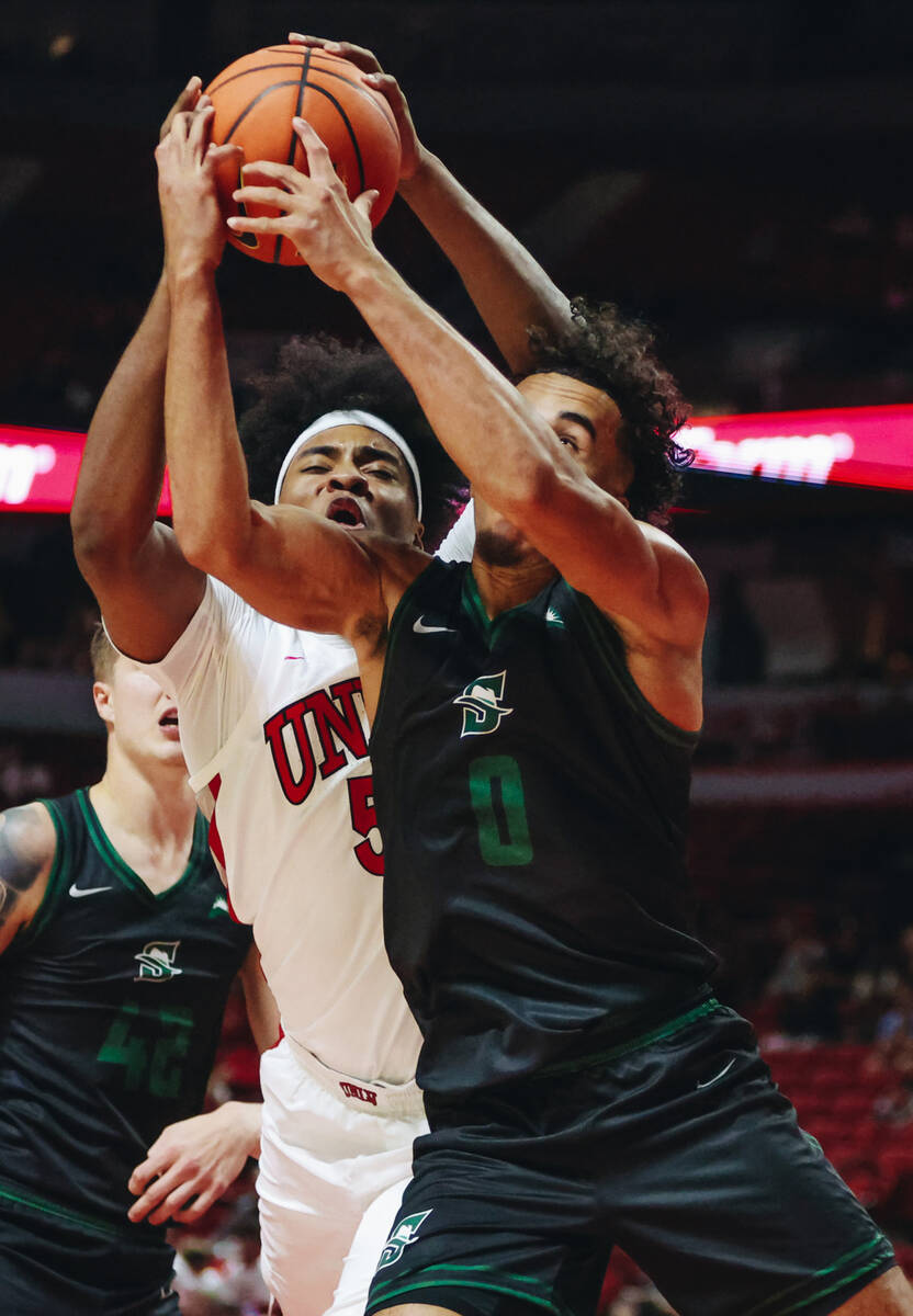 UNLV forward Rob Whaley Jr. (5) and Stetson guard Alec Oglesby (0) fight for the ball during a ...
