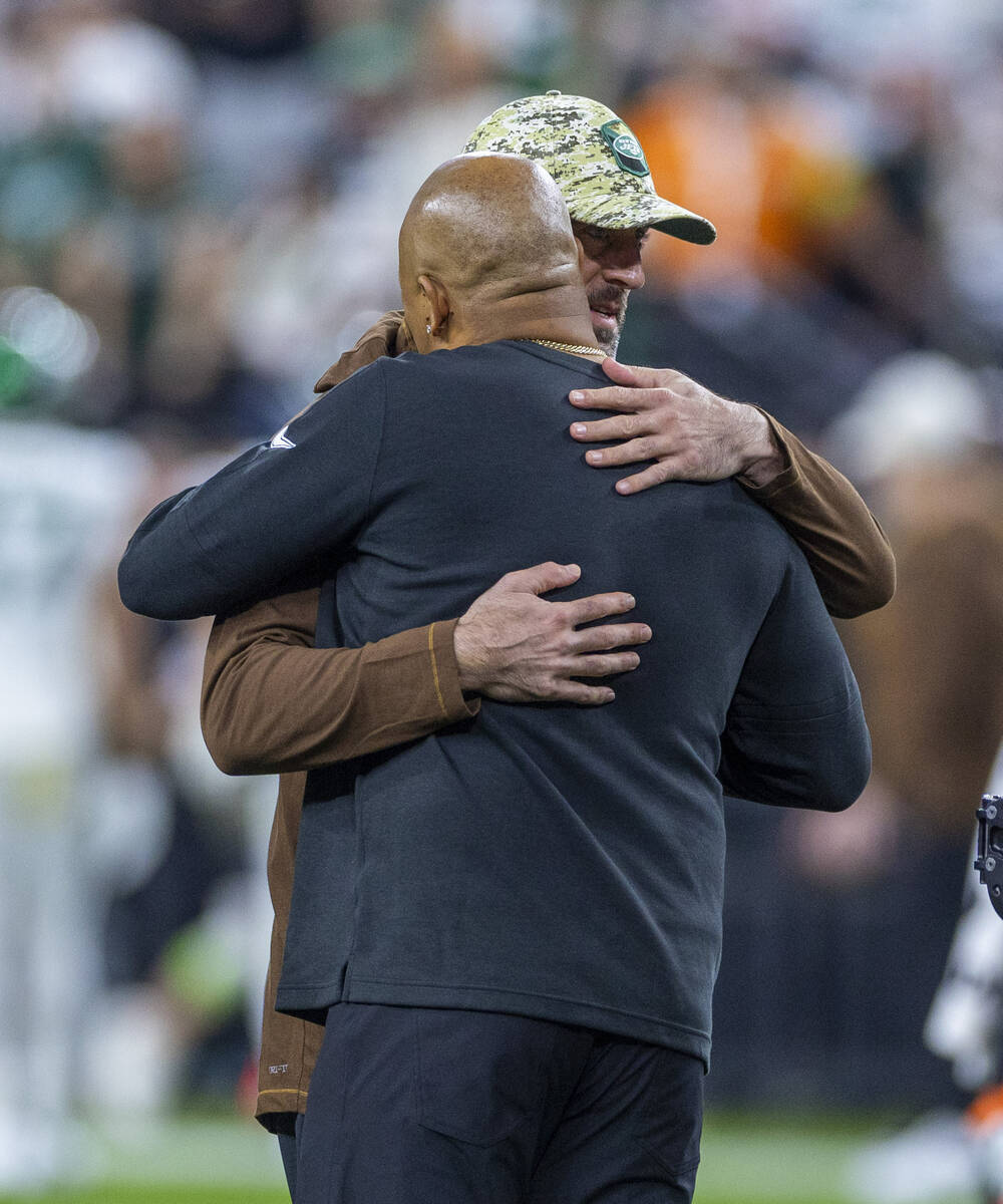 Raiders head coach Antonio Pierce hugs New York Jets quarterback Aaron Rodgers before the first ...