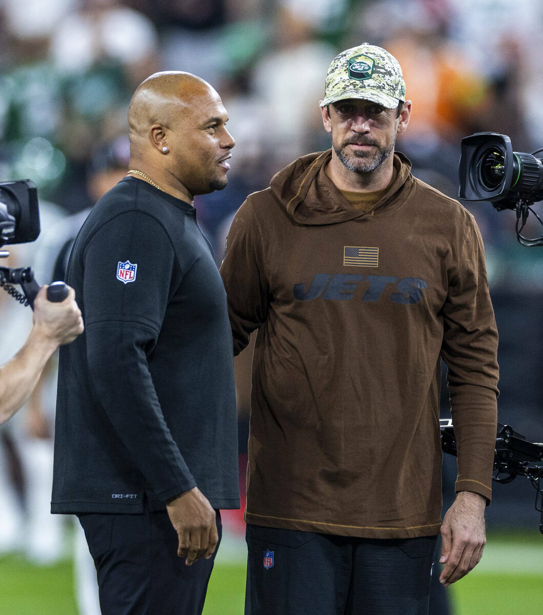 Raiders head coach Antonio Pierce talks with New York Jets quarterback Aaron Rodgers before the ...