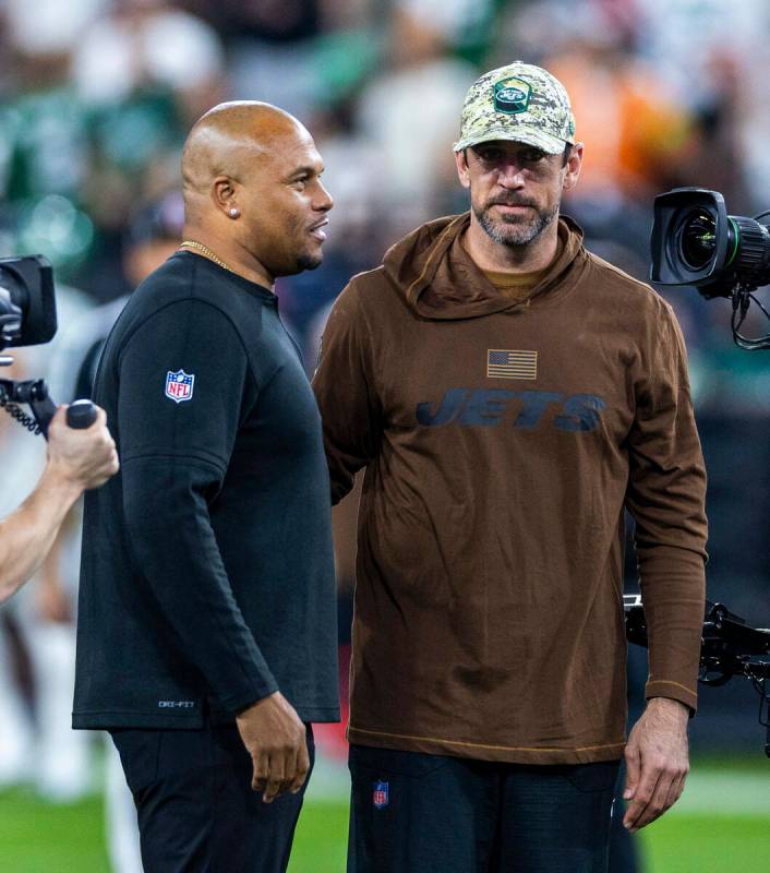 Raiders head coach Antonio Pierce talks with New York Jets quarterback Aaron Rodgers before the ...