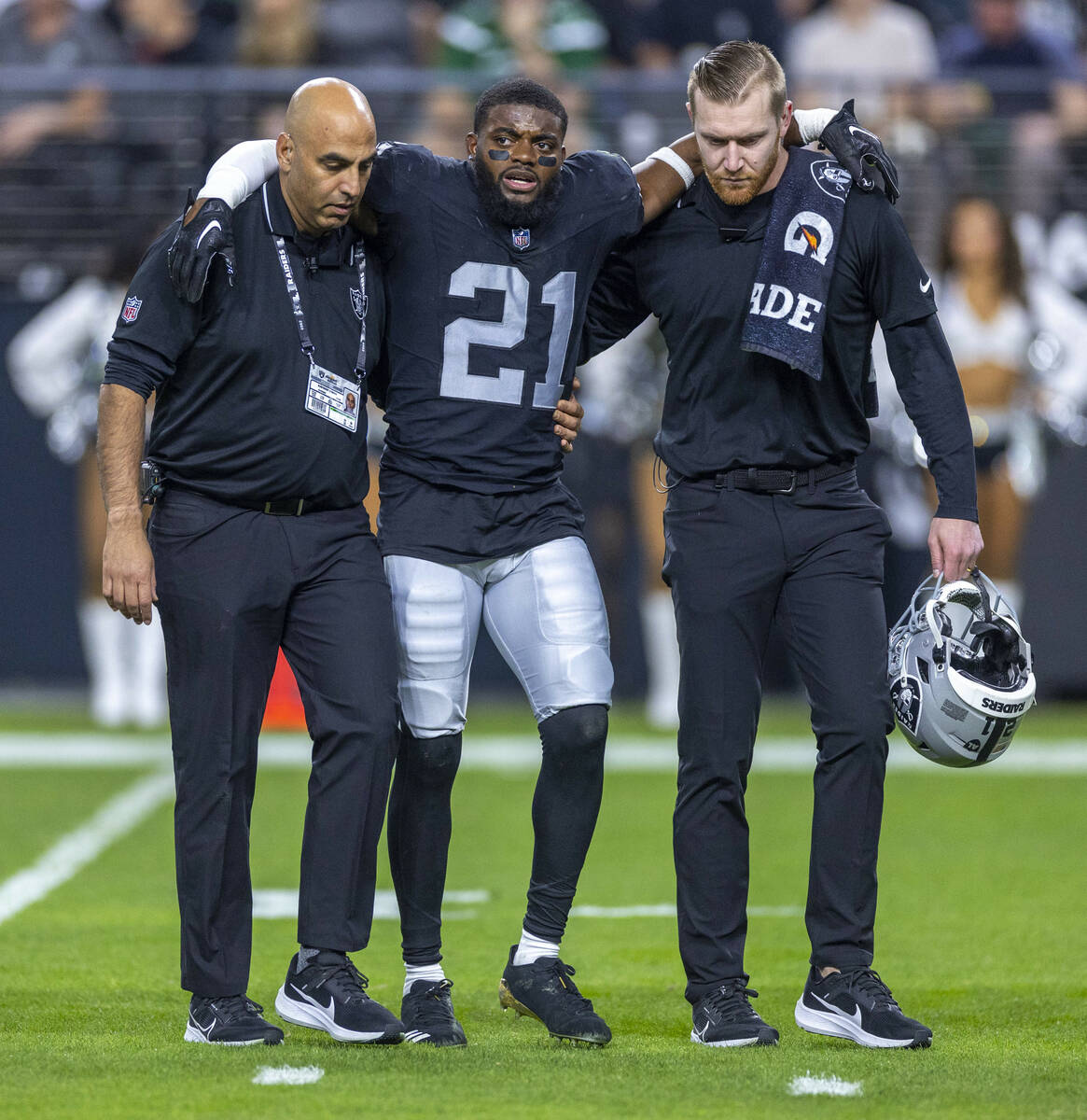 Raiders cornerback Amik Robertson (21) is assisted off the field after an injury against the Ne ...