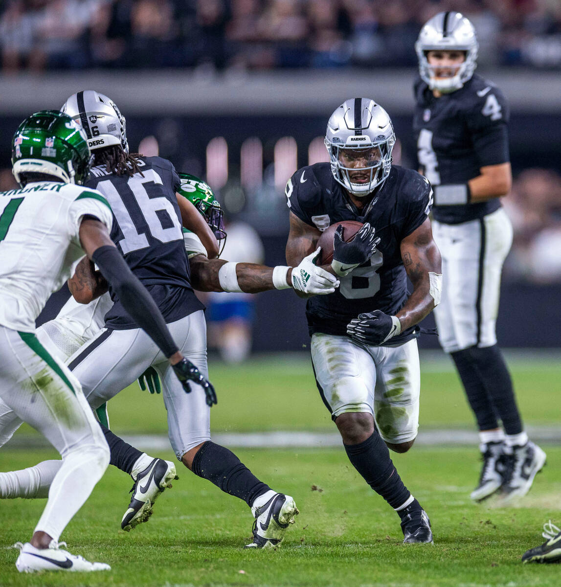 Raiders running back Josh Jacobs (8) blast through the line looking for more yards against New ...