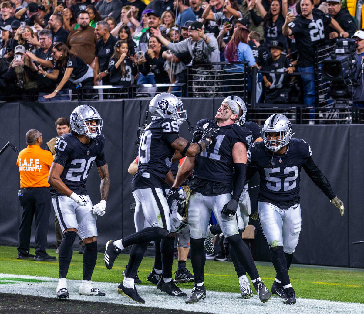 Raiders linebacker Robert Spillane (41) is celebrated for a critical late interception by teamm ...