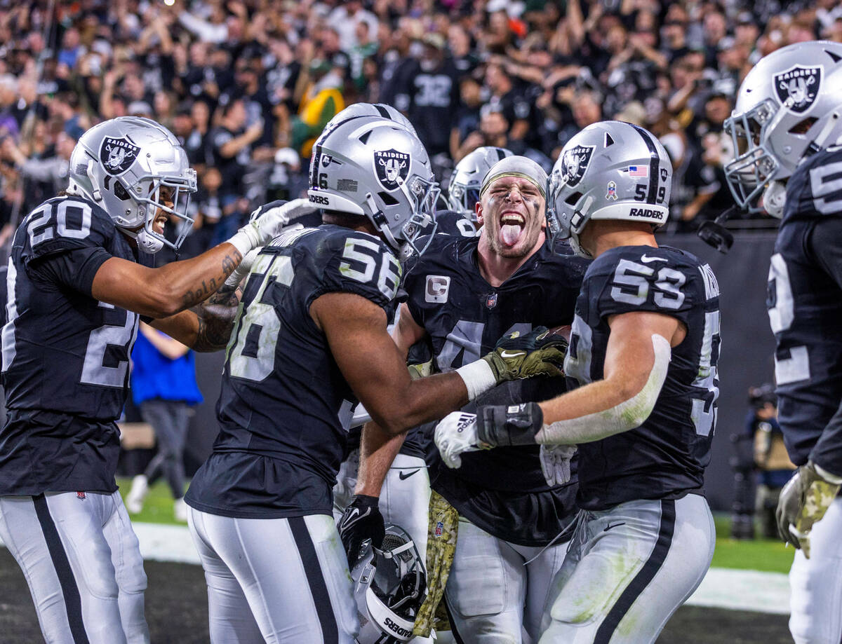 Raiders linebacker Robert Spillane (41) is celebrated for a critical late interception by teamm ...