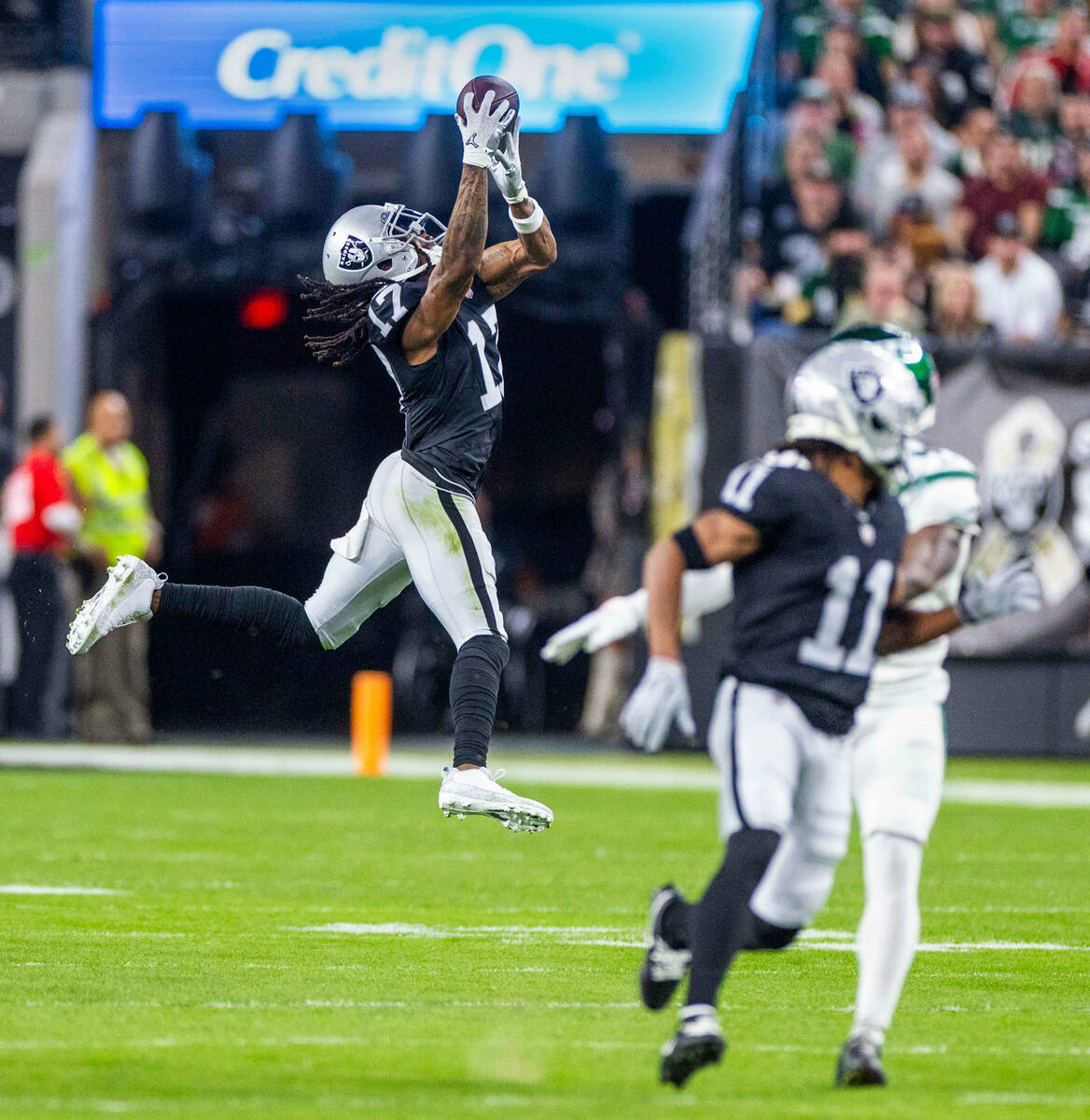 Raiders wide receiver Davante Adams (17) elevates for a catch over the New York Jets defense du ...