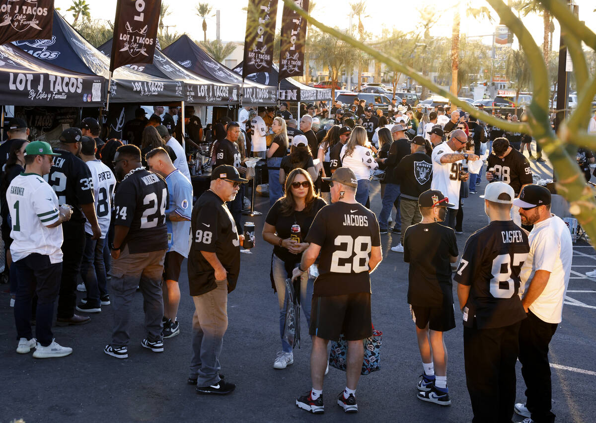 Raiders fans tailgate outside Allegiant Stadium before the start of an NFL football game agains ...