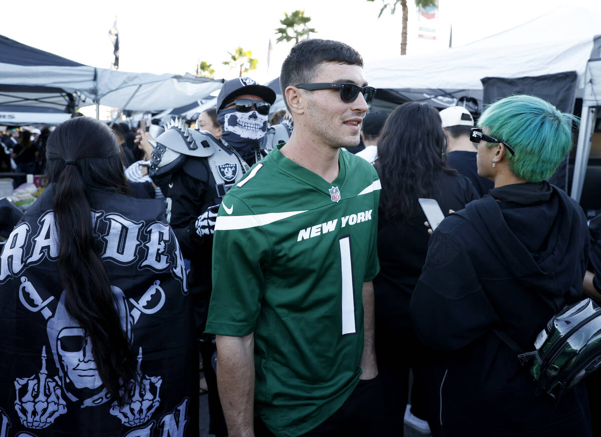 New York Jetts fan Andrew Sheehan navigates through Raiders fans at a tailgate outside Allegian ...