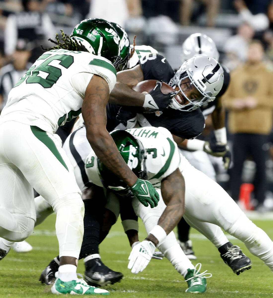 Raiders running back Josh Jacobs (8) taken down by New York Jets defense during the first half ...