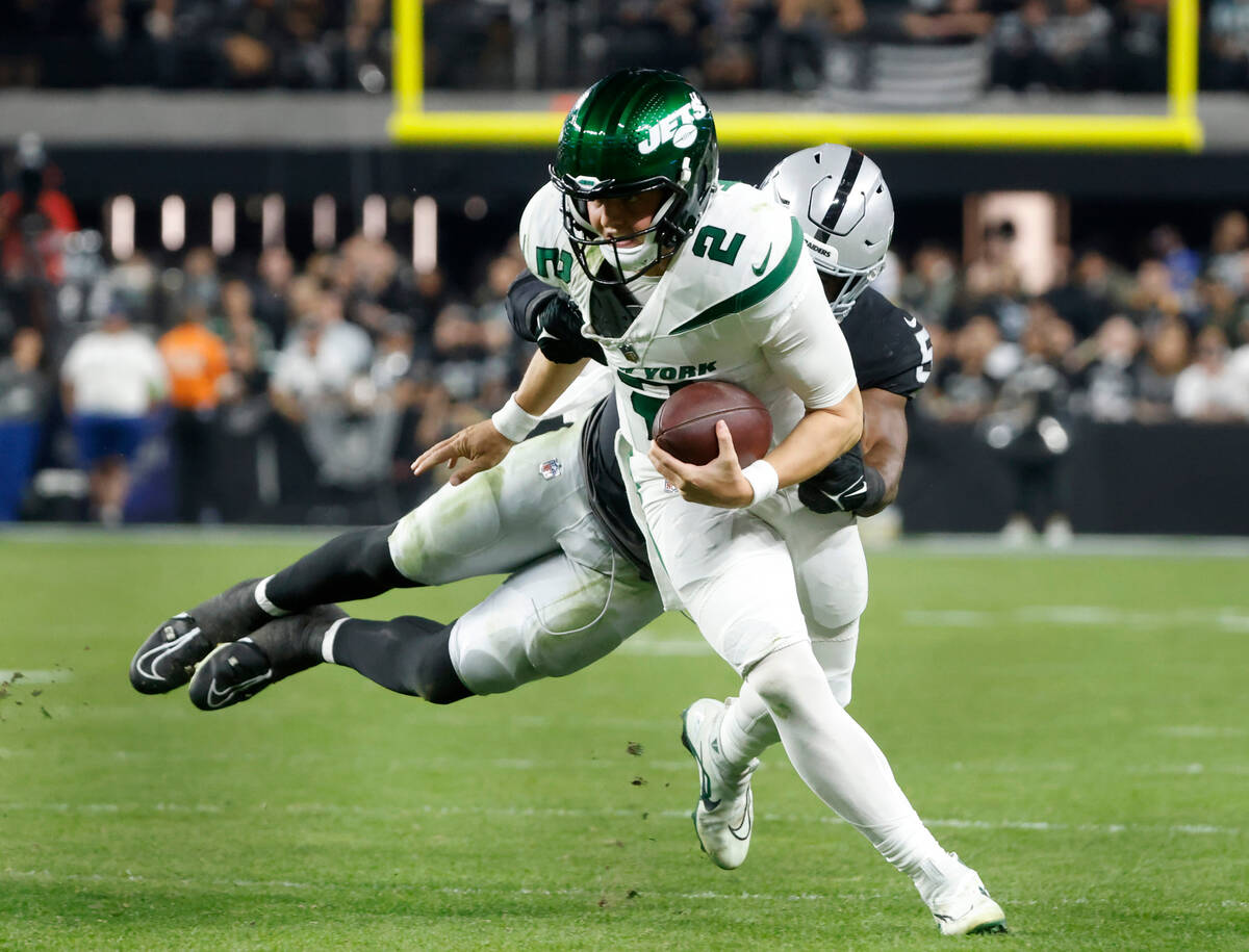 New York Jets quarterback Zach Wilson (2) is taken down by Raiders linebacker Divine Deablo (5) ...