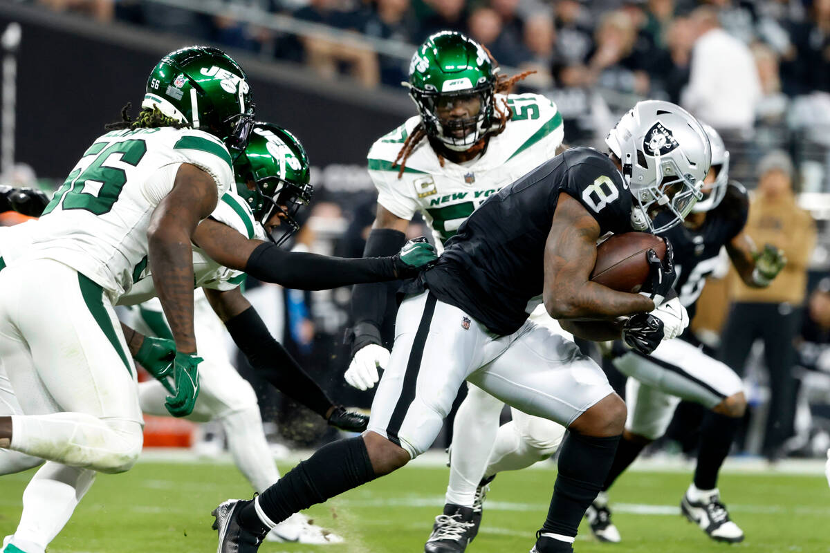 Raiders running back Josh Jacobs (8) evades a tackle from New York Jets defense during the firs ...