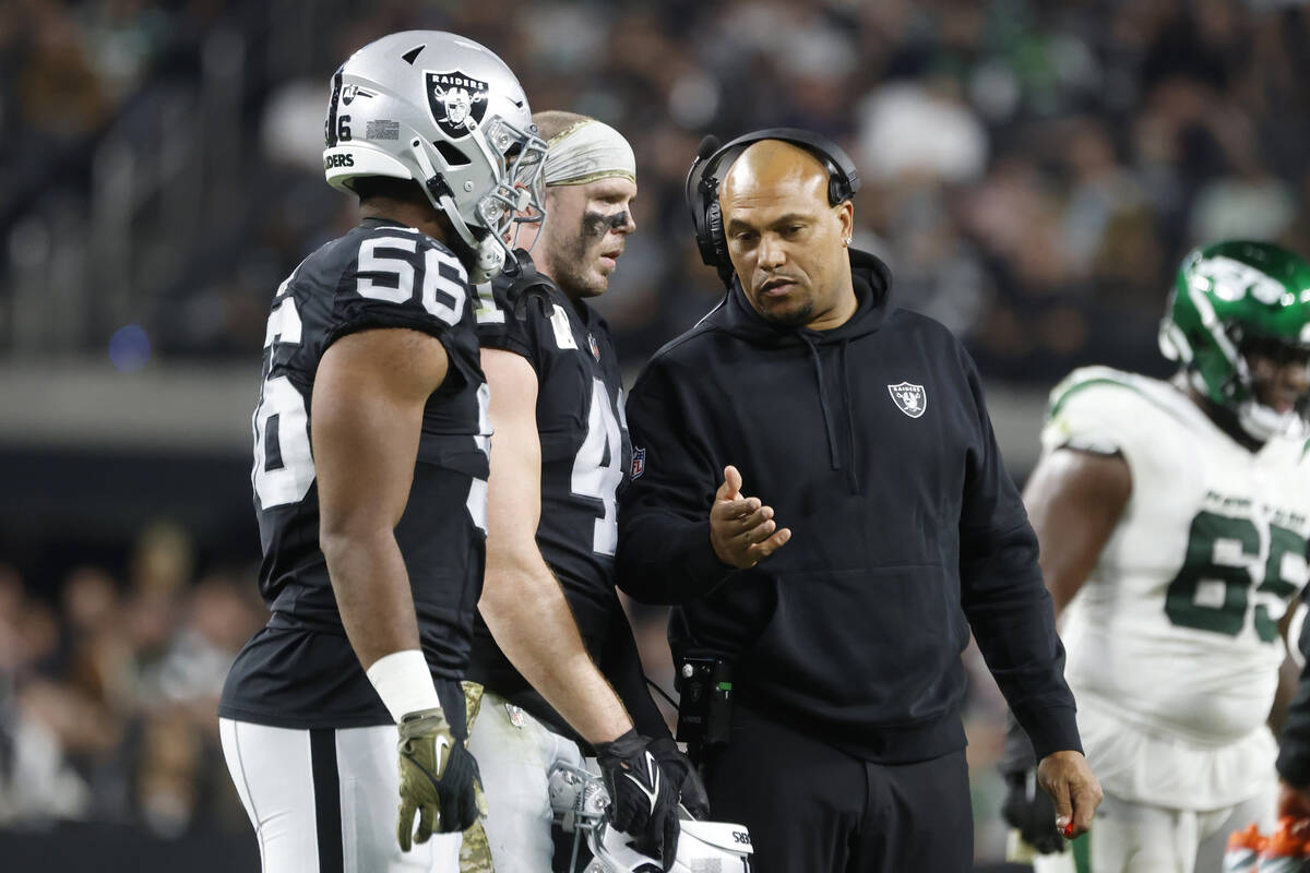 Raiders Interim Coach Antonio Pierce talks to linebackers Amari Burney (56) and Robert Spillane ...