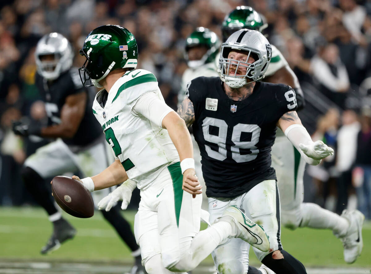 New York Jets quarterback Zach Wilson (2) is chased by Raiders defensive end Maxx Crosby (98) d ...