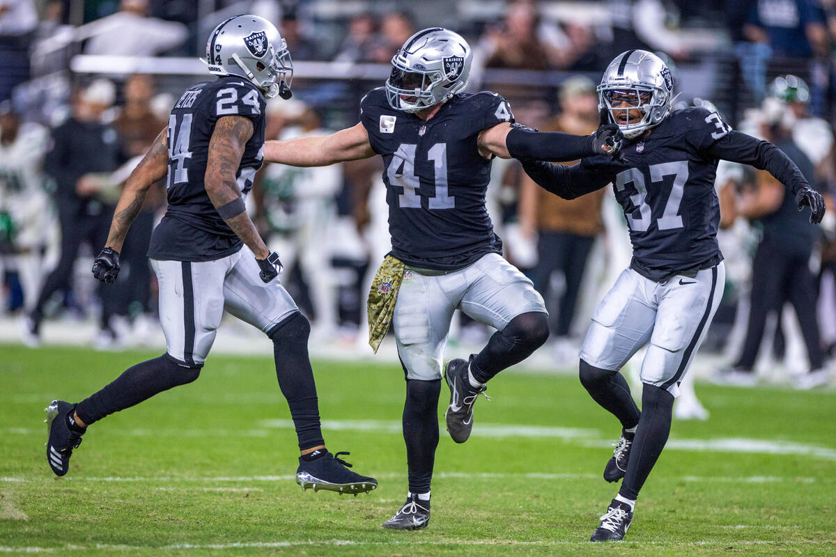 Raiders linebacker Robert Spillane (41) celebrates a late interception with teammate cornerback ...