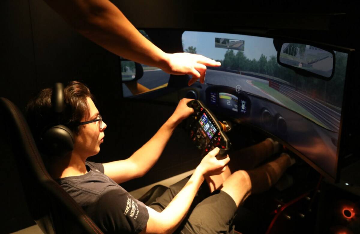 A McLaren simulator coach helps Joseph Launi, visiting from Toronto, Canada for the Formula 1 r ...