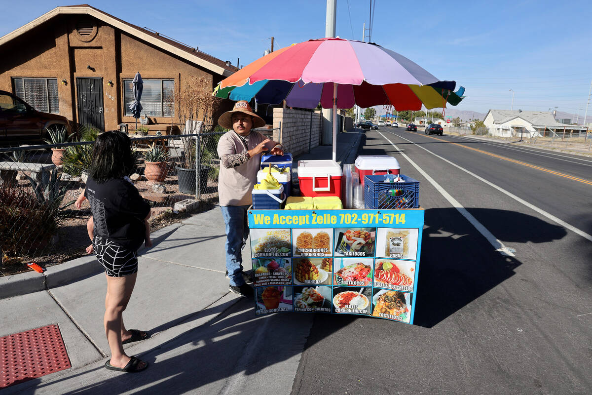 Street vendor Luis Serrano serves customers in the Historic Westside in Las Vegas Tuesday, Nov. ...