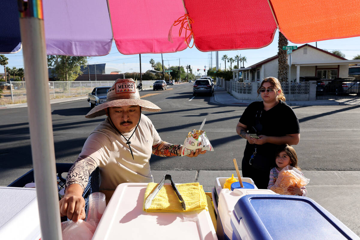 Street vendor Luis Serrano serves Leslie Ortega and her daughter Grace, 4, in the Historic West ...
