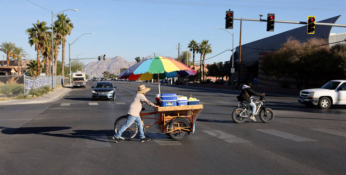 Street vendor Luis Serrano rolls his cart to serve customers in the Historic Westside in Las Ve ...