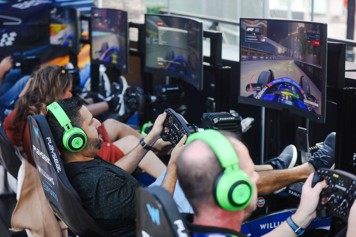 Guests play Formula 1 race video games at the Williams Racing Fanzone, a pop up up for the Las ...