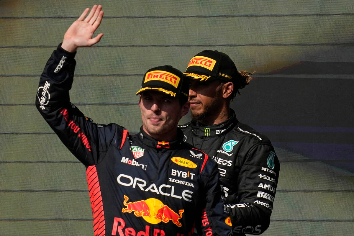 Red Bull driver Max Verstappen, of the Netherlands, left, waves on the podium in front Mercedes ...