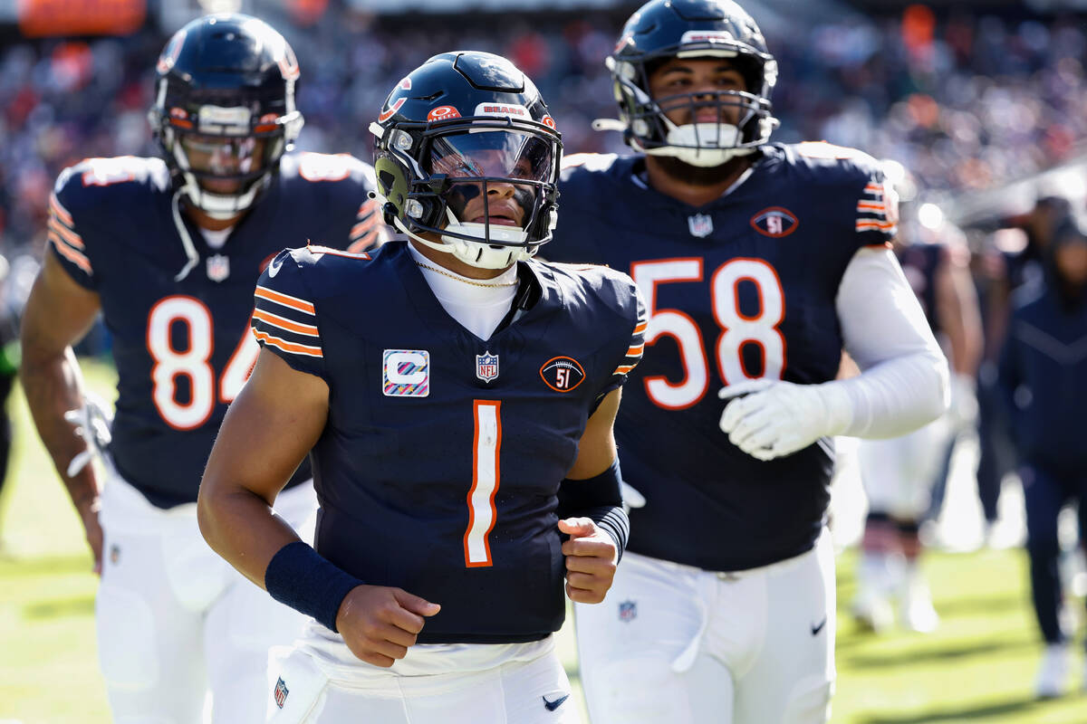 FILE - Chicago Bears quarterback Justin Fields (1) jogs off the field after the first half of t ...