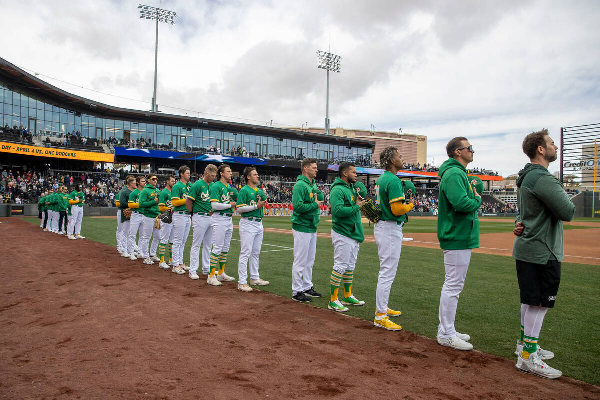 The Oakland Athletics remove their ball caps for the national anthem before a baseball game aga ...