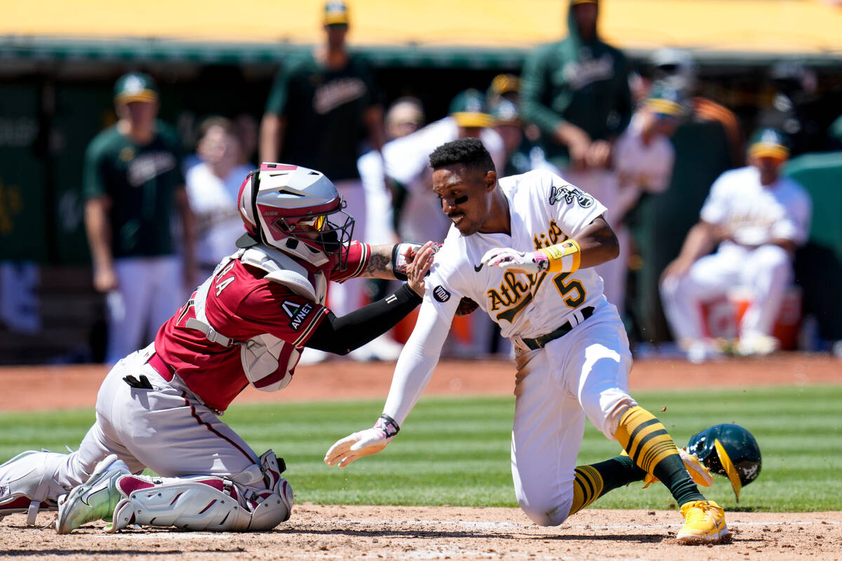 Arizona Diamondbacks catcher Jose Herrera, left, tags out Oakland Athletics' Tony Kemp at home ...