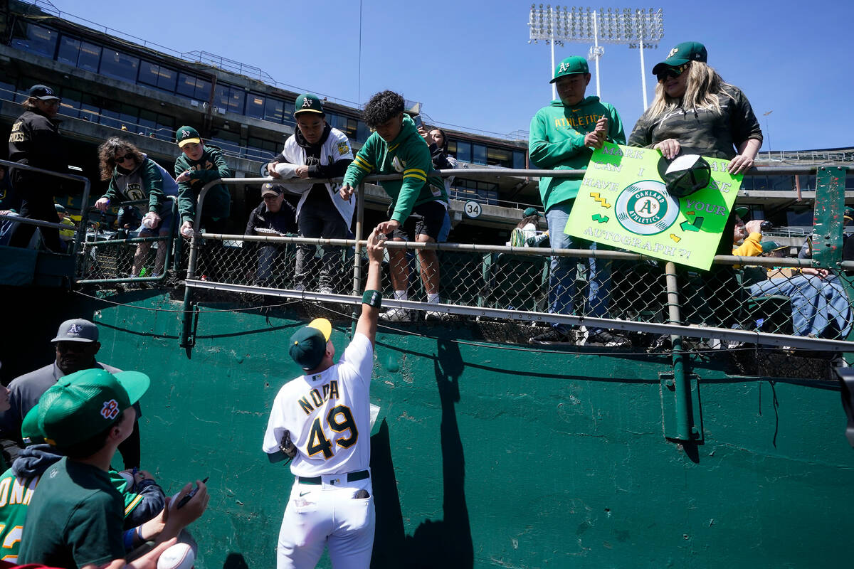 Oakland Athletics' Ryan Noda signs autographs for fans before a baseball game against the Cleve ...
