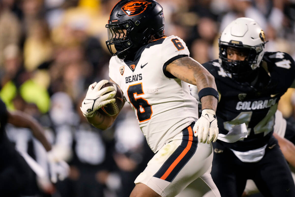 Oregon State running back Damien Martinez runs for a short gain as Colorado linebacker Jordan D ...