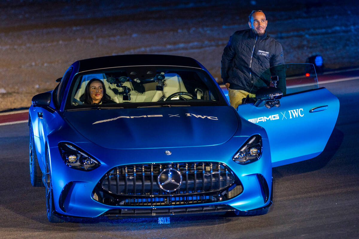 Mercedes-AMG driver Lewis Hamilton stands beside a new GT after a drone show during the Mercede ...
