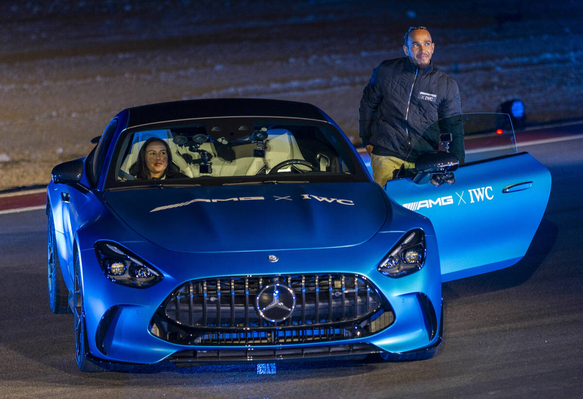 Mercedes-AMG driver Lewis Hamilton stands beside a new GT after a drone show during the Mercede ...